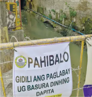  ?? SUNSTAR FOTO / ARNI ACLAO ?? HELP PREVENT FLOODS. A message from the Cebu City Government reminds passersby not to toss their garbage into this waterway between Colon and V. Gullas Sts.