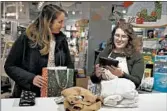  ?? ERIN HOOLEY/CHICAGO TRIBUNE ?? Halle Wagner, right, helps Katherine Gailey return items purchased online from Everlane at a Paper Source on Nov. 12. Paper Source works with a company called Happy Returns to process returns for other brands.