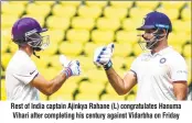  ??  ?? Rest of India captain Ajinkya Rahane (L) congratula­tes Hanuma Vihari after completing his century against Vidarbha on Friday