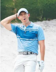  ??  ?? ALMOST: Rory McIlroy reacts to a near-miss from a bunker.