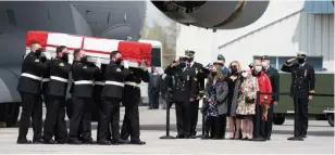  ?? FRANK GUNN THE CANADIAN PRESS ?? Family members look on as masked pallbearer­s carry the casket of Sub-Lt. Abbigail Cowbrough during a repatriati­on ceremony at Canadian Forces Base Trenton on Wednesday.