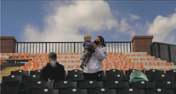  ?? Carlos Avila Gonzalez / The Chronicle ?? Kyle and Justine Wichman sit in the stands with their baby son Grady, 10 months old, before the Giants faced the Angels at Scottsdale Stadium on Feb. 28.