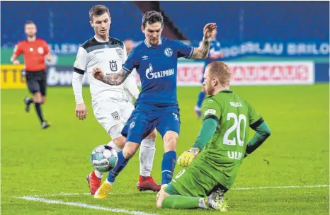  ?? FOTO: GUIDO KIRCHNER/DPA ?? Hier scheitert Schalkes Matchwinne­r Benito Raman gegen den Ulmer Torwart Maximilian Reule und Thomas Geyer, später traf er doppelt.