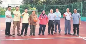  ??  ?? SERAH: Rubiah menyempurn­akan simbolik penyerahan Gelanggang Futsal Kampung Merdang Gayam sambil disaksi penduduk kampung dan wakil Jabatan Kerja Raya Samarahan.