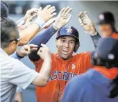  ?? Otto Greule Jr. / Getty Images ?? Astros outfielder George Springer works the dugout receiving line after his 12th homer of the season, a solo shot in the ninth inning.