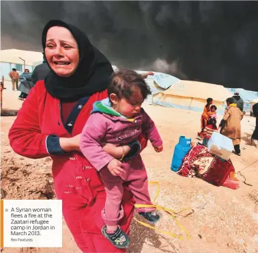  ?? Rex Features ?? A Syrian woman ■ flees a fire at the Zaatari refugee camp in Jordan in March 2013.