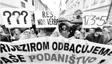  ??  ?? Croatian students gather under the rain in downtown Zagreb to voice their support of Bosnian Croats and protest the recent verdict by a UN war crimes court against six Bosnian Croat wartime political and military leaders. — AFP photo