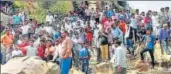  ?? PTI ?? People gather near the lake in which three men drowned.