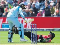  ?? PAUL ELLIS AFP/GETTY IMAGES ?? England’s Jason Roy, left, collides with West Indies umpire Joel Wilson as he takes a run in the Cricket World Cup on Saturday.