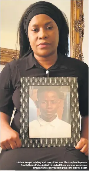  ??  ?? > Alina Joseph holding a picture of her son, Christophe­r Kapessa. South Wales Police initially insisted there were no suspicious circumstan­ces surroundin­g the schoolboy’s death