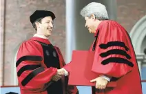 ??  ?? Zuckerberg, left, is presented with an honorary Doctor of Laws degree by Harvard Vice President Marc Goodheart.