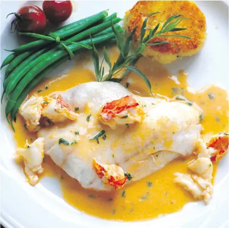  ??  ?? Roasted ling cod in lobster sauce is served with steamed green beans, sautéed cherry tomatoes and potato cakes.