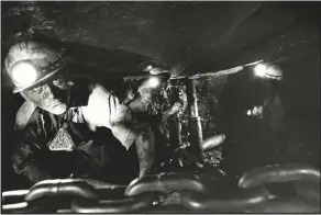  ??  ?? A miner, lit only by the lamps of his fellow workers, on the coal seam at Creswell Colliery