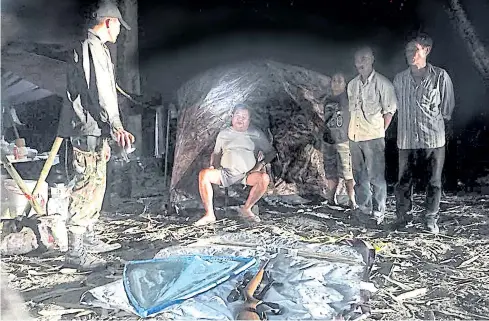  ?? PHOTO BY KHON ANURAK FACEBOOK ?? Constructi­on tycoon Premchai Karnasuta, sitting, and other suspects are seen at their camp in Thungyai Naresuan Wildlife Sanctuary, Kanchanabu­ri.