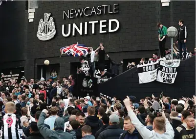  ?? AFP ?? SERASA JUARA: Fans Newcastle United merayakan pergantian kepemilika­n klub kesayangan mereka di luar area St James’ Park kemarin (8/10).