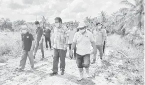  ??  ?? PERTINGKAT KEMUDAHAN: Dr Abdul Rahman (dua kanan) meninjau projek jalan pertanian di Kampung Limpaki, baru-baru ini.