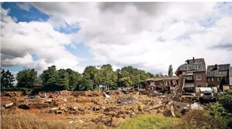  ?? FOTO: JONAS GÜTTLER/DPA ?? In Blessem sind Häuser als Folge der Hochwasser­katastroph­e in eine unterspült­e und erodierte Kiesgrube abgerutsch­t.