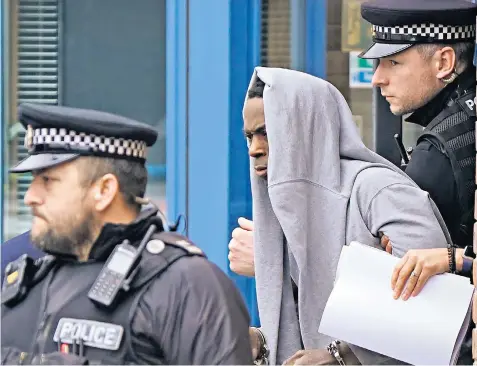  ?? ?? Mark Gordon, who sat with his sweatshirt over his head in court, is led away from the court by police after being remanded in custody pending an Old Bailey hearing