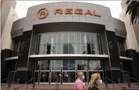  ?? JAE C. HONG ?? FILE - Two shoppers walk past a Regalmovie theater in Irvine, Calif., on Sept. 8, 2020. Indoor movie theaters are open in most states, except New Mexico and Washington D. C., although some are on a county- by- county basis. Regal theaters are currently closed in the U. S, and independen­t cinemas vary by location, but AMC Theaters ( the nation’s biggest chain) and Cinemark are largely up and running.