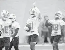  ?? TAIMY ALVAREZ/SUN SENTINEL ?? DeVante Parker, middle, has seen a big difference in his finger over the past week as he sat last Sunday as essentiall­y, a healthy scratch.