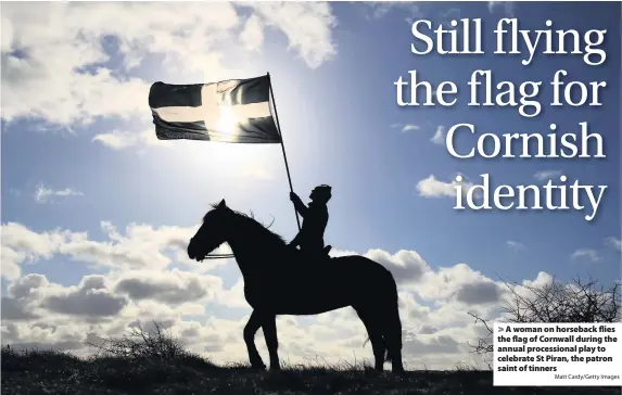  ?? Matt Cardy/Getty Images ?? A woman on horseback flies the flag of Cornwall during the annual procession­al play to celebrate St Piran, the patron saint of tinners