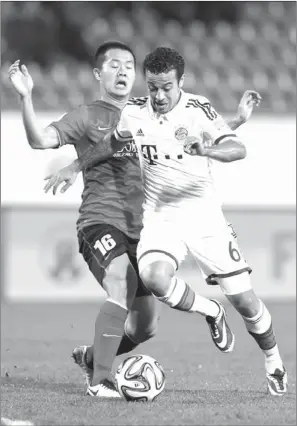  ?? CHRISTOPHE ENA / ASSOCIATED PRESS ?? Bayern’s Thiago Alcantara (right) challenges Guangzhou Evergrande’s Huang Bowen during their semifinal match at the Club World Cup tournament in Agadir, Morocco, on Tuesday. Bayern won 3-0 to advance to the final on Saturday.