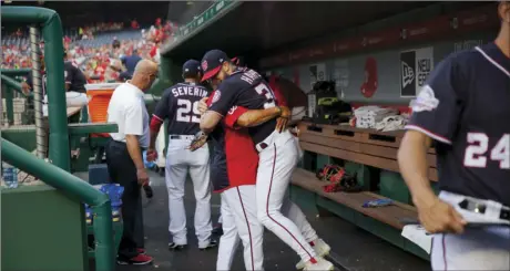  ?? AP PHOTO/PABLO MARTINEZ MONSIVAIS ?? In this May 4, 2018, photo, Washington Nationals Bryce Harper is hugged and lifted off the ground by his manager Dave Martinez in the dugout prior to the start of a baseball game against the Philadelph­ia Phillies at Nationals Park in Washington. High fives and fist bumps are out. Hugs are a no-go. And just like crying, there’s no spitting in baseball, at least for now. Things sure will be different when it’s time to play ball in two weeks.