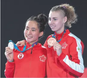  ?? CP PHOTO ?? Canada’s Jessica Guo, left, silver medallist, and teammate Eleanor Harvey, bronze medallist, pose after the women’s foil individual event at the Pan Am Games in Lima, Peru, on Monday.