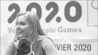  ?? ALEXANDRA WEY, THE ASSOCIATED PRESS ?? American skier Lindsey Vonn, ambassador for the Winter Youth Olympic Games Lausanne 2020, holds her dog Lucy as she speaks Sunday with children of the skiing club Alpina, in St. Moritz, Switzerlan­d.