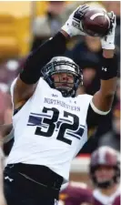  ?? HANNAH FOSLIEN/GETTY IMAGES ?? NU linebacker Nate Hall snares the first of his two intercepti­ons Saturday against Minnesota.