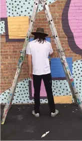  ?? COURTESY OF LEFT HANDED WAVE ?? RIGHT: Left Handed Wave works on a mural at 55th Street and Pulaski Road as a part of a nationwide “Wall Project” in August 2017.