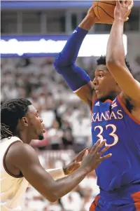  ?? BRAD TOLLEFSON/ASSOCIATED PRESS FILE ?? Kansas 7-footer David McCormack looks to pass over former Texas Tech player Chris Clarke on March 7. Like Clarke, McCormack grew up in Virginia Beach and played in the TCIS.