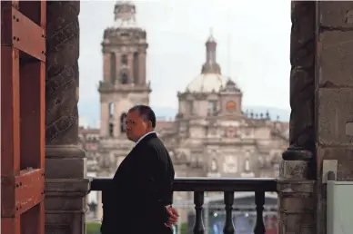  ??  ?? An official from the presidency looks on from atop Old City Hall, ahead of the start of a rally on the one-year anniversar­y of Mexican President Andrés Manuel López Obrador’s election, in Mexico City’s main square on Monday.