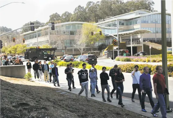  ?? Scott Strazzante / The Chronicle ?? YouTube employees leave the building single-file after police responded to the shooting situation and secured the company’s headquarte­rs in San Bruno.