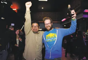  ??  ?? Evan Owski, a tech worker who rallied for Prop. C, and Miguel Carrera, organizer at the Coalition on Homelessne­ss, celebrate at the Yes on C campaign watch party in the Mission.