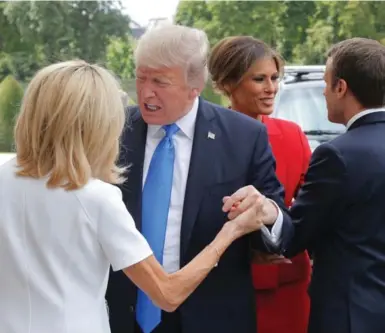  ?? MICHEL EULER/AFP/GETTY IMAGES ?? French President Emmanuel Macron and his wife Brigitte Macron greet the Trumps in Paris on July 13. “Watching President Trump schlep around Paris in a perpetual state of faux pas . . . was excruciati­ng but amusing,” writes Heather Mallick..