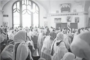  ?? COLUMBUS DISPATCH ADAM CAIRNS/ ?? People of Ethiopian descent, including Kdusan Araya, middle, of Bexley and her mother, Tshainesh Mesfin, attend the Palm Sunday service at Holy Trinity Ethiopian Orthodox Tewahedo Church on the Near East Side.