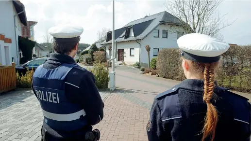  ?? (foto di Michael Probst/Ap) ?? La sorveglian­za Due poliziotti tedeschi vicino alla casa dove viveva il copilota Andreas Lubitz, a Montabaur (in Renania) per non far avvicinare i giornalist­i