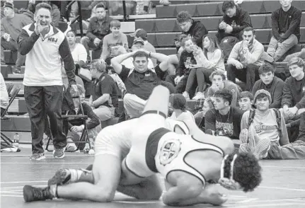  ?? ULYSSES MUÑOZ/THE BALTIMORE SUN ?? Mount St. Joseph coach Harry Barnabae shouts to Chris Barnabae as he wrestles Saturday against Colin Dupill of Liberty (Va.).