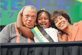  ?? IAN ALLEN/PHOTOGRAPH­ER ?? Courtney Greaves (centre), a student of Jessie Ripoll Primary School, hugs Dr Peter Phillips, president of the People’s National Party (PNP), and former party president Portia Simpson Miller, after delivering a message on crime.