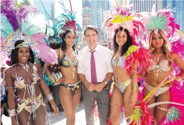 ?? CHRIS YOUNG / THE CANADIAN PRESS ?? Prime Minister Justin Trudeau stops for a photo with dancers from the Toronto Caribbean Carnival on Friday.