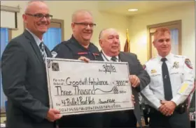  ?? EVAN BRANDT — DIGITAL FIRST MEDIA ?? From left, Lower Pottsgrove Township Manager Ed Wagner, Goodwill Ambulance EMT Erik Loshnowsky, Township Commission­er Ray Lopez and Lower Pottsgrove Police Chief Mike Foltz with a township check to help pay for bulletproo­f vests for Goodwill EMTs.