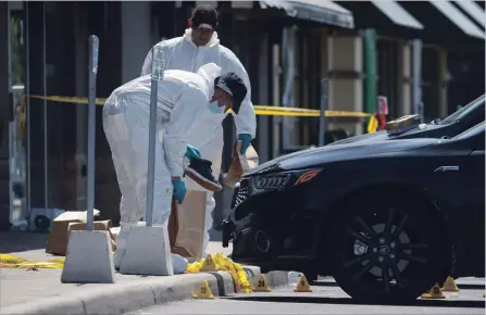  ?? COLE BURSTON
THE CANADIAN PRESS ?? Police forensic officers work around the scene where an improvised explosive device ripped through a Mississaug­a restaurant on Thursday night.