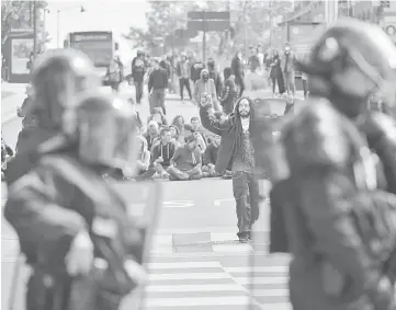  ??  ?? A protester juggles in front of policemen during a demonstrat­ion against the results of the first round of the French presidenti­al election in Rennes, western France. — AFP photo