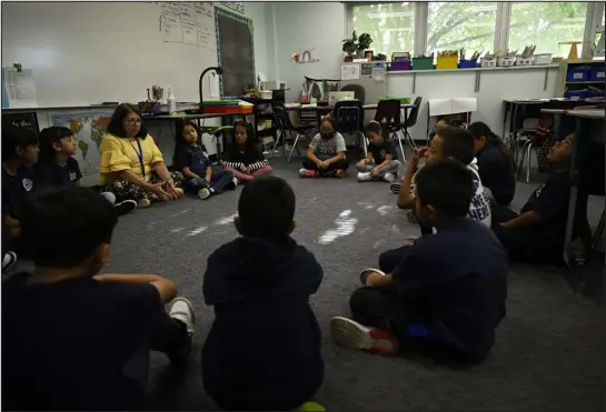  ?? RJ SANGOSTI — DENVER POST FILE ?? Students in Denise Saiz’s third-grade classroom gather on the floor for a morning lesson at Castro Elementary, a small bilingual school in the Denver Public Schools system, in 2022. Denver Public Schools has more than 45,000student­s who identify as Hispanic or Latino — 51.8% of all students.