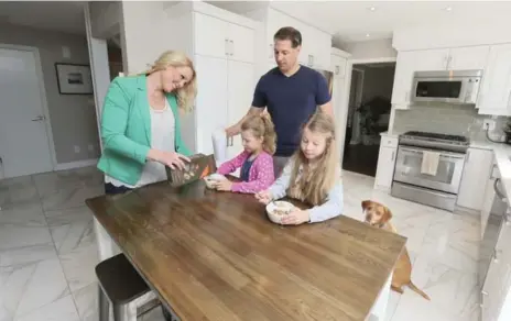  ?? ANDREW FRANCIS WALLACE/TORONTO STAR ?? NOW: “The kitchen to me was where we really won,” says Wagar, with her family, about the $10,000 they spent to upgrade the room.