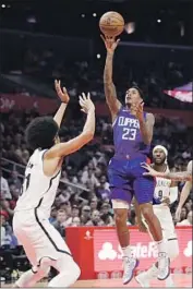  ?? Marcio Jose Sanchez Associated Press ?? LOU WILLIAMS, shooting over the Nets’ Jarrett Allen on Sunday, came up clutch again at the end with a buzzer-beating three-pointer for the Clippers.