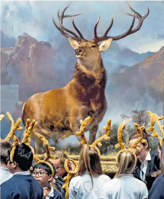  ??  ?? Copycats Schoolchil­dren wearing antlers to mark the occasion study The Monarch of the Glen by Sir Edwin Landseer, which is to tour Scottish galleries. The painting was saved for the nation by the National Galleries of Scotland earlier this year.