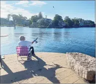  ?? Susan Braden / Hearst Connecticu­t Media ?? This fisherman looks like he got a prime spot on the newly refurbishe­d town dock in Branford, which was closed all summer due to repairs and lumber shortages.