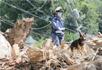  ??  ?? A member of Maritime Self Defence Forces searches for missing persons at a flood damage site in Kure, Hiroshima prefecture. — AFP photo